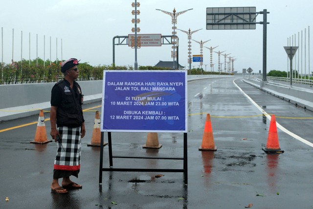 Pecalang atau petugas pengamanan adat Bali memantau situasi jalan tol Bali Mandara saat Hari Raya Nyepi Tahun Baru Saka 1946 di Desa Adat Tuban, Badung, Bali, Senin (11/3/2024). Foto: Nyoman Hendra Wibowo/ANTARA FOTO