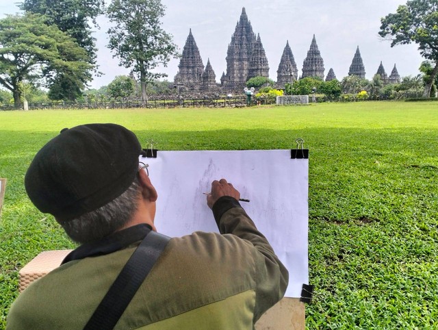 Salah seorang pelukis sedang menggambar suasana Candi Prambanan di Hari Raya Nyepi. Foto: M Wulan