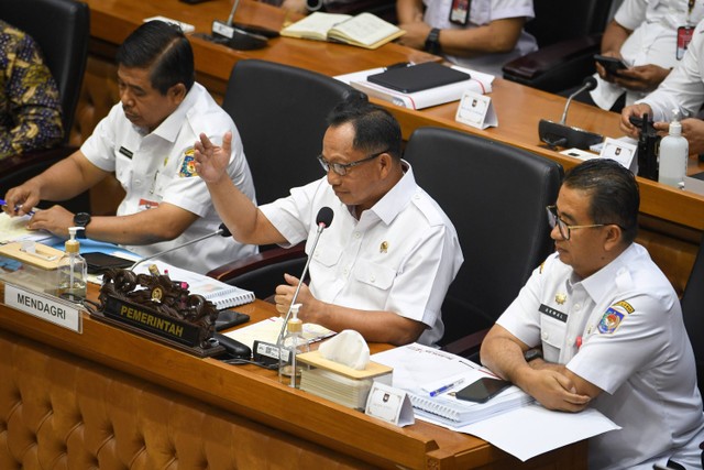 Menteri Dalam Negeri (Mendagri) Tito Karnavian (tengah) bersama jajarannya menyampaikan pandangannya dalam rapat kerja mengenai kelanjutan Rancangan Undang-Undang Daerah Khusus Jakarta (RUU DKJ) bersama Badan Legislasi (Baleg) DPR dan DPD. Foto: Aditya Pradana Putra/Antara Foto