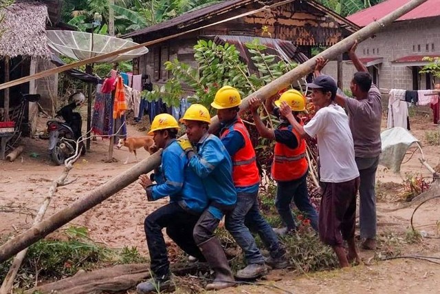 Petugas PLN gotong royong bersama masyarakat memperbaiki tiang listrik yang roboh akibat bencana banjir dan longsor yang menerjang Kabupaten Pesisir Selatan, Sumatera Barat, pada Senin (11/3/2024). Foto: PLN