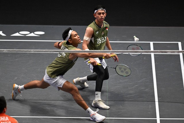 Fajar Alfian (Kiri) dari Indonesia dan Muhammad Rian Ardianto (kanan) dari Indonesia akan bermain melawan Aaron Chia dari Malaysia dan Soh Wooi Yik dari Malaysia di Final Ganda Putra di Kejuaraan Bulutangkis All England Open. Foto: JUSTIN TALLIS / AFP