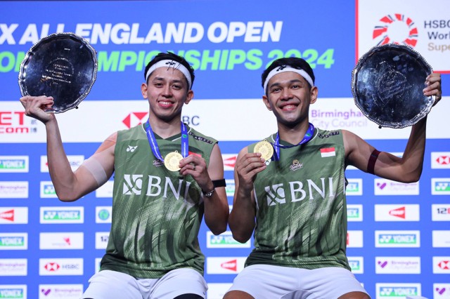 Pebulu tangkis ganda putra Indonesia Fajar Alfian (kanan) dan Muhammad Rian Ardianto (kiri) memperlihatkan piala dan medalinya usai mengalahkan ganda putra Malaysia Aaron Chia/Soh Wooi Yik dalam final All England Open 2024. Foto: HO-PBSI/Antara Foto