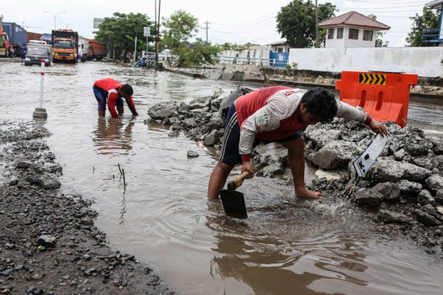 Petugas menggali endapan tanah untuk membuat jalur drainase air banjir supaya dapat terbuang ke arah Kali Tenggang di kawasan Jalan Pantura Kaligawe Raya, Semarang, Jawa Tengah, Senin (18/3/2024). Foto: Makna Zaezar/ANTARA FOTO