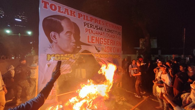 Massa aksi tolak pemilu curang membakar spanduk berwajah Jokowi hingga Anwar Usman di depan Gedung KPU RI, Jakarta Pusat, Senin (18/3/2024). Foto: Jonathan Devin/kumparan