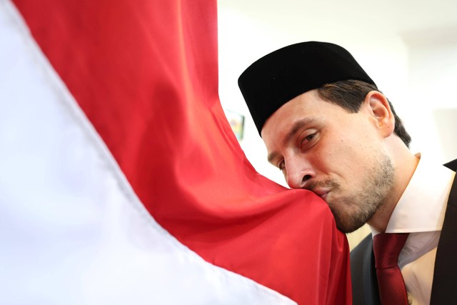 Thom Haye mencium bendera Merah Putih usai menjalani sumpah WNI di Kanwil Kemenkumham Jakarta pada 18 Maret 2024. Foto: PSSI