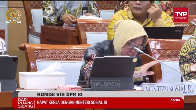 Mensos Tri Rismaharini menangis saat rapat kerja bersama komisi VIII, Selasa (18/3). Foto: Tangkapan Layar TV Parlemen