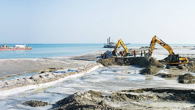 Dua buah alat berat sedang mengeruk pasir laut. Ilustrasi: shutterstock