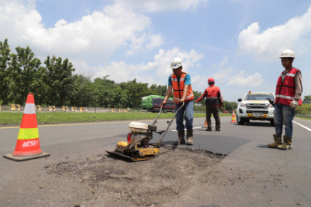 Petugas memperbaiki jalan berlubang di ruas Tol Cikopo Palimanan (Cipali) KM 122, Rabu (20/3/2024). Foto: Dicky Adam Sidiq/kumparan