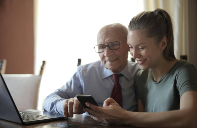 Ilustrasi: Prasangka Generasi Sumber: https://www.pexels.com/positive-senior-man-and-smiling-young-woman-watching-smartphone-while-sitting-at-table-3824768/