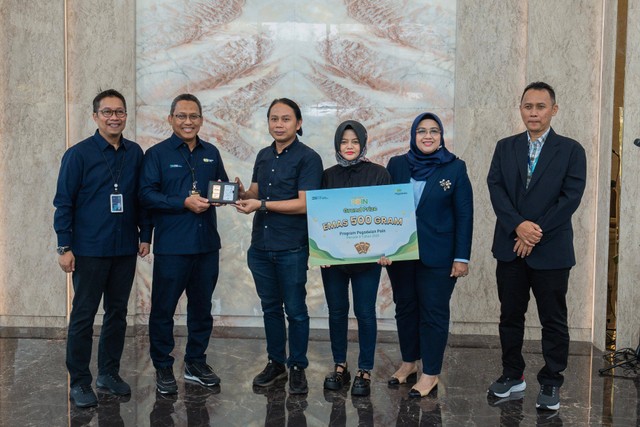 Penyerahan hadiah utama emas 500 gram dari Direktur Utama PT Pegadaian, Damar Latri Setiawan, kepada pemenang Program Pegadaian Poin II, Dede Rudi, di The Gade Tower, Jakarta, Kamis (21/3). Foto: Pegadaian