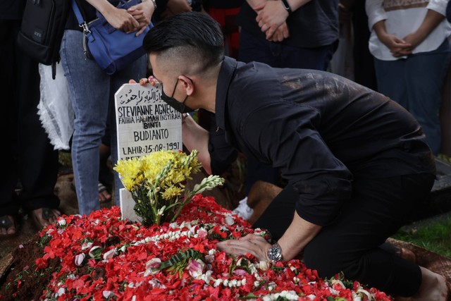 Sejumlah keluarga dan kerabat saat mencium makam jenazah almarhum Stevie Agnecya di TPU Tanah Kusir, Jakarta, Jumat, (22/3/2024) Foto: Agus Apriyanto