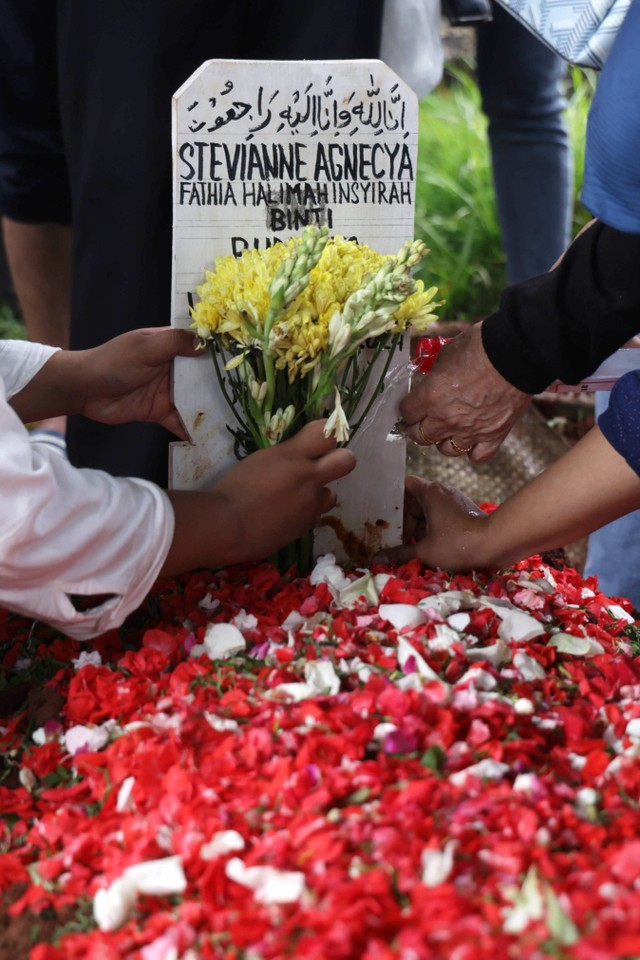 Sejumlah keluarga dan kerabat menabur bunga ke makam jenazah almarhum Stevianne Agnecya di TPU Tanah Kusir, Jakarta, Jumat, (22/3/2024). Foto: Agus Apriyanto