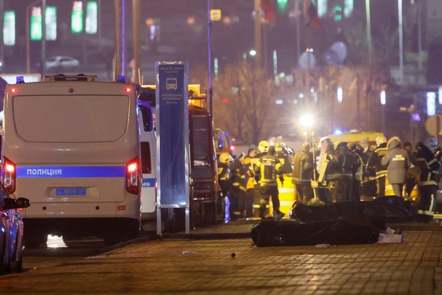 Para ahli berkumpul di dekat mayat orang-orang yang terbunuh di dekat tempat konser Balai Kota Crocus setelah insiden penembakan, di luar Moskow, Rusia, Sabtu (23/3/2024). Foto: Maxim Shemetov/REUTERS