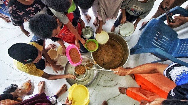 Tradisi tahunan pembagian bubur suro selalu menjadi momen yang dinanti puluhan warga maupun Anak-anak yang tinggal di kawasan Masjid Suro Palembang, Sabtu (23/3) Foto: ary priyanto/urban id