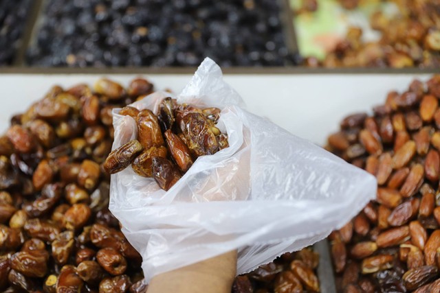 Pedagang melayani pembeli buah kurma di salah satu toko kurma kawasan Pasar Tanah Abang, Jakarta, Minggu, (24/3/2024). Foto: Iqbal Firdaus/kumparan