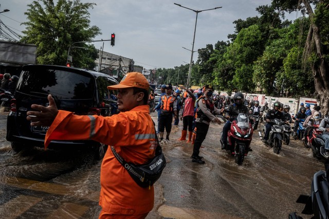 Petugas gabungan mengatur arus lalu lintas di dekat proyek tanggul Kali Hek yang jebol di kawasan Kramat Jati, Jakarta, Senin (25/3/2024). Foto: Aprillio Akbar/ANTARA FOTO