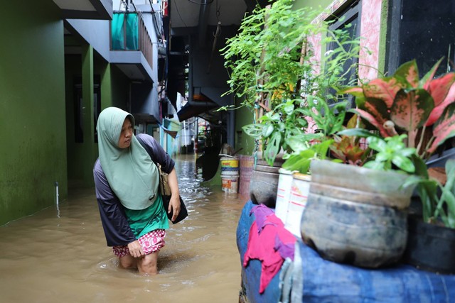 Warga melintasi banjir yang merendam kawasan Kebon Pala, Jakarta Timur, Senin (25/3/2024). Foto: Iqbal Firdaus/kumparan