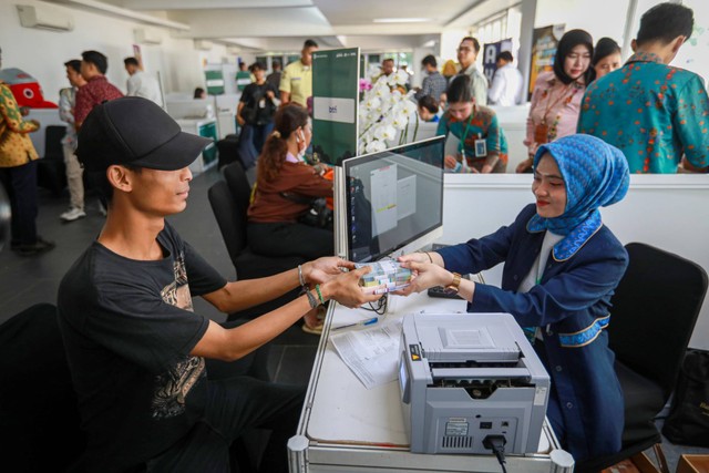 Petugas Bank melayani penukaran uang di Layanan Kas Keliling Terpadu pada momen Ramadan dan Idul Fitri 2024 di Istora Senayan, Jakarta, Kamis (28/3/2024). Foto: Aditia Noviansyah/kumparan