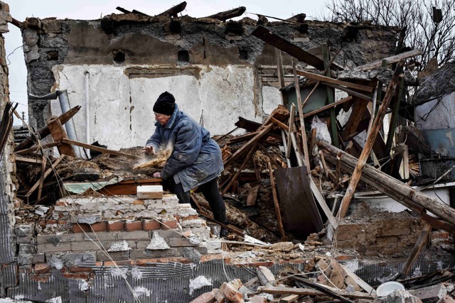 Inna, 71, membersihkan puing-puing setelah rumahnya dihancurkan oleh serangan drone Rusia di lingkungan perumahan, di Zaporizhzhia, Ukraina, Kamis, (28/3/2024) Foto: Andriy Andriyenko/AP Photo