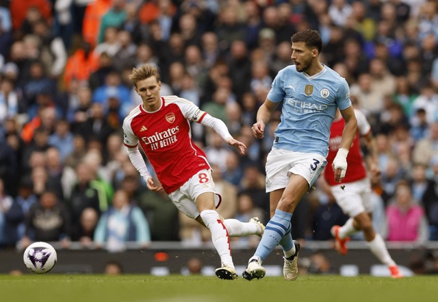 Duel Martin Odegaard dengan Rodri Hernandez saat laga Man City vs Arsenal dalam lanjutan Liga Inggris 2023/24 di Stadion Etihad pada Minggu (31/3) malam WIB.  Foto: Action Images via Reuters/Jason Cairnduff