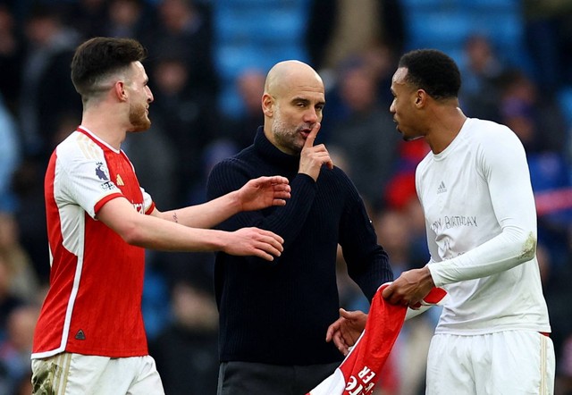 Pep Guardiola bicara dengan Gabriel Magalhaes dan Declan Rice usai laga Man City vs Arsenal dalam lanjutan Liga Inggris 2023/24 di Stadion Etihad pada Minggu (31/3) malam WIB. Foto: REUTERS/Carl Recine