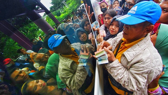 Antrean warga di lokasi penukaran uang di area staisun LRT Palembang jelang lebaran, Senin (1/4) Foto: ary priyanto/urban id