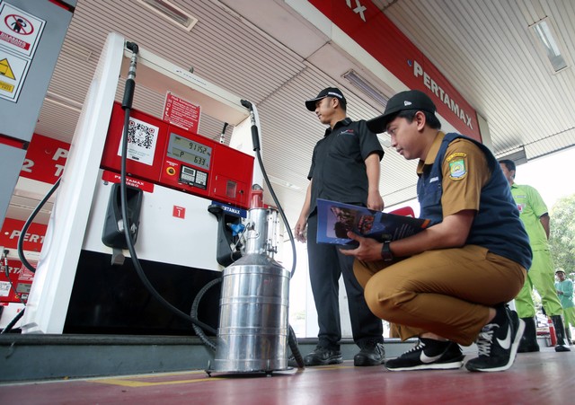 Petugas UPT Pelayanan Metrologi Legal Dinas Perindustrian Perdagangan Koperasi dan UKM (Perindagkopukm) Kota Tangerang periksa dispenser mesin pengisi BBM di SPBU 34-15137 Rest Area Tol Tangerang - Jakarta, Tangerang, Banten, Senin (1/4/2024) Foto: Muhammad Iqbal/ANTARA FOTO