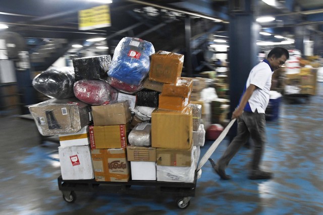 Seorang petugas membawa paket barang menggunakan troli di TIKI Station Pemuda, Rawamangun, Jakarta Timur, Senin (1/4/2024). Foto: Fakhri Hermansyah/ANTARA FOTO