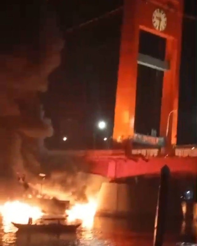 Suasana kapal yang terbakar terbawa arus ke arah Jembatan Ampera Palembang, Foto : Istimewa