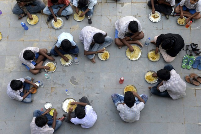 Siswa menyantap makanan saat istirahat makan siang di sebuah sekolah menengah negeri di pinggiran Hyderabad, India, pada 23 November 2021. Foto:  NOAH SEELAM / AFP