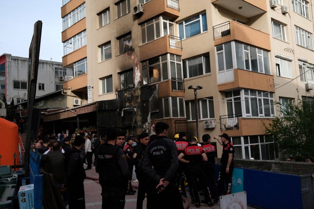 Petugas polisi berdiri di samping sebuah gedung setelah kebakaran terjadi saat pekerjaan renovasi siang hari di sebuah klub malam, di Istanbul, Turki, Selasa (2/4/2024). Foto:  Murad Sezer/REUTERS