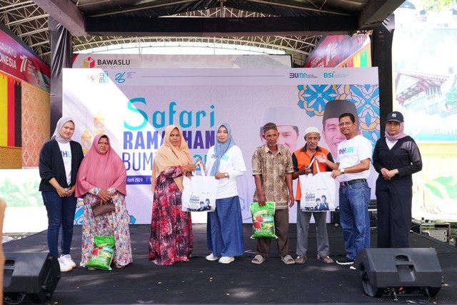 Deputy Institutional Banking & Government Relation BSI Region Aceh, Saiful Musadir (kiri kedua), dan Deputy Operasional BSI Regional Aceh, Willi Diana (kanan keempat), menyerahkan paket sembako murah kepada masyarakat pada acara Safari Ramadhan BUMN di Aceh, Selasa (2/4). Foto: dok. BSI