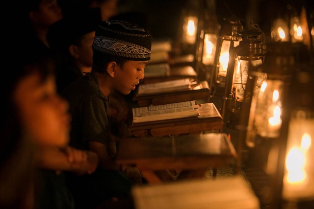 Sejumlah anak mengaji dengan penerangan lampu lilin saat pengajian Tadarus Al Quran di kampung Prajurit Wirotamtomo, Baluwarti, Solo, Jawa Tengah, Rabu (3/4/2024). Foto: Mohammad Ayudha/ANTARA FOTO