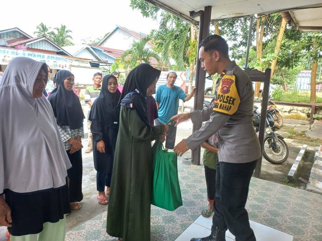 Kapolsek Nanga Mahap Ipda Eric Ibrahim Pattimura memberikan bantuan paket sembako kepada warga. Foto: Dok. Polsek Nanga Mahap