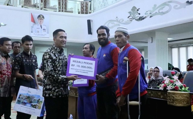 Pj Wali Kota Palembang, Ratu Dewa, saat membagikan bonus kepada para atlet. (ist)