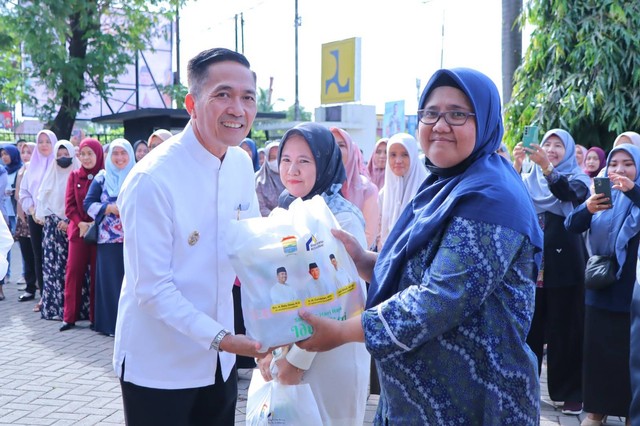 Pj Wali Kota Palembang, Ratu Dewa, saat membagikan paket sembako dan THR kepada tenaga PHL di Palembang. (ist)