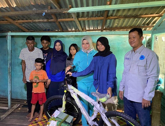 Ketua IKASMANSA Pontianak sekaligus Ketua TP PKK Kalbar saat mengantarkan sepeda ke rumah Dinda. Foto: Yulia Ramadhiyanti/Hi!Pontianak