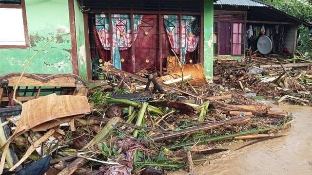 Rumah warga di Kota Bitung, Sulawesi Utara, tertimbun sampah dan batang kayu usai banjir melanda.