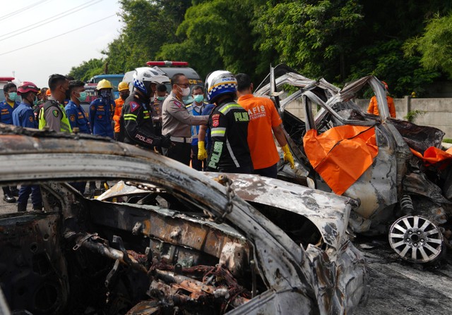 Polisi memeriksa bangkai kendaraan yang mengalami kecelakaan di Tol Jakarta-CIkampek KM 58, Karawang Timur, Jawa Barat, Senin (8/4/2024). Foto: Akbar Nugroho Gumay/ANTARA FOTO