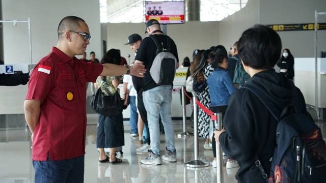 Kepala Kemenkumham Sulawesi Utara, Ronald Lumbuun, berinteraksi dengan penumpang di Bandara Sam Ratulangi Manado.