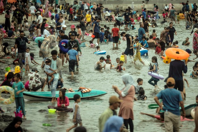 Sejumlah warga berwisata saat libur lebaran di Pantai Lagoon, Taman Impian Jaya Ancol, Jakarta, Kamis (11/4/2024). Foto: Aprillio Akbar/ANTARA FOTO