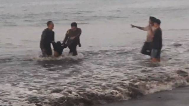 Personel Polisi dan TNI saat menolong korban seorang remaja yang tenggelam di Pantai Pinagut, Bolmong Utara, Sulawesi Utara. 