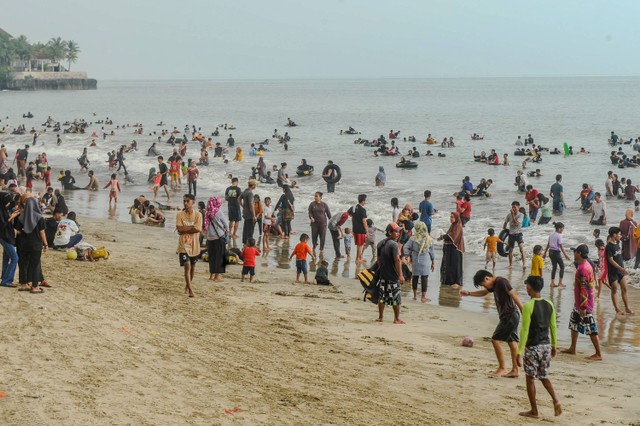 Wisatawan mengunjungi Pantai Anyer, Kabupaten Serang saat libur Lebaran 2024, Sabtu (13/4/2024). Foto: Muhammad Bagus Khoirunas/ANTARA FOTO