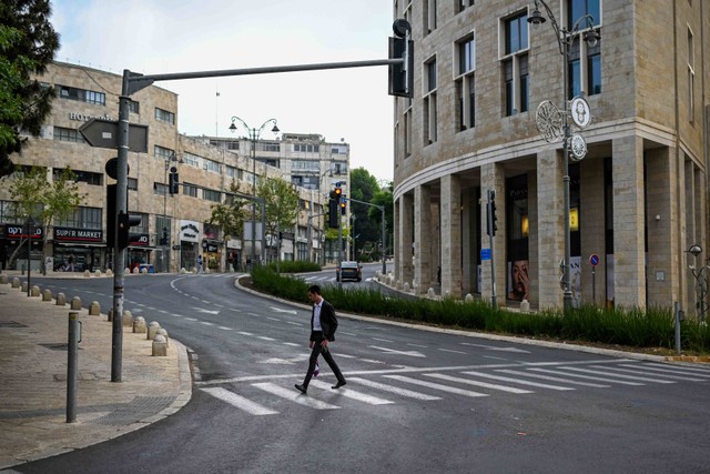 Warga Israel kembali beraktivitas dengan normal sepanjang jalan di Yerusalem, Minggu (14/4/2024). Foto: Ronaldo Schemidt/AFP