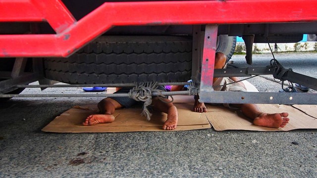 Dua orang sopir truk yang beristirahat di terminal AAL usai dilarang melintas demi menghindari kemacetan, Minggu (14/4) Foto: ary priyanto/urban id