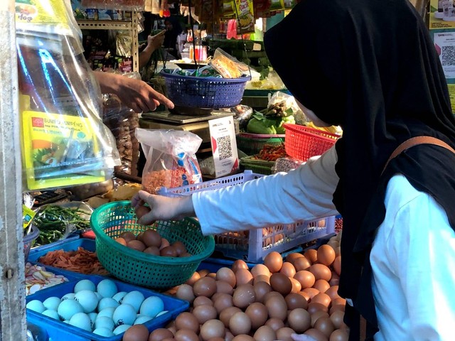 Foto: Seorang ibu sedang membeli bahan makanan di pasar menjelang lebaran.