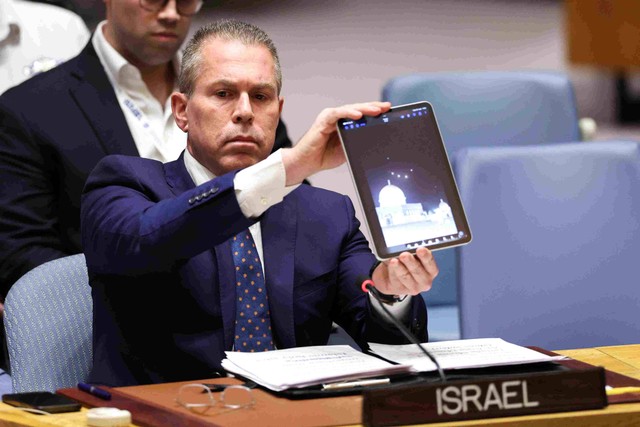 Duta Besar Israel untuk PBB Gilad Erdan menunjukkan video drone dan rudal menuju Israel selama pertemuan Dewan Keamanan PBB di markas besar PBB di New York, Kamis (14/4/2024) Foto: Charly Triballeau/AFP