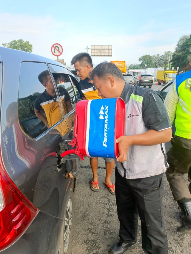 Tim motorist Pertamina saat mengisi BBM ke mobil yang mogok di ruas tol arah Jakarta. Foto: Dok. Pertamina