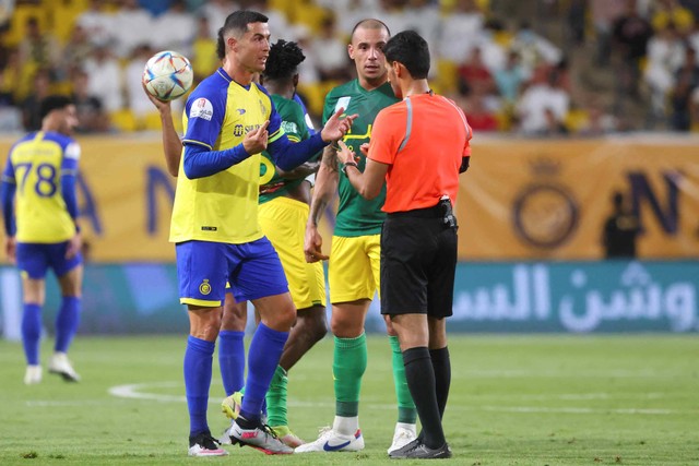 Penyerang Nassr asal Portugal Cristiano Ronaldo (kiri) berbicara dengan wasit Saudi Majed Al-Shamrani selama pertandingan sepak bola Liga Pro Saudi antara Al-Nassr dan Al-Khaleej di Stadion al-Awwal Park di ibu kota Saudi, Riyadh (8/5/2023) Foto: FAYEZ NURELDINE / AFP