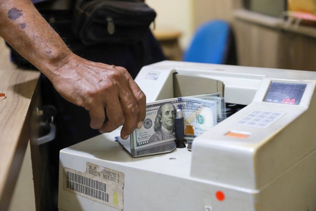 Petugas menghitung pecahan mata uang Dolar di salah satu gerai penukaran mata uang di kawasan Kemang, Jakarta, Rabu (17/4/2024). Foto: Iqbal Firdaus/kumparan